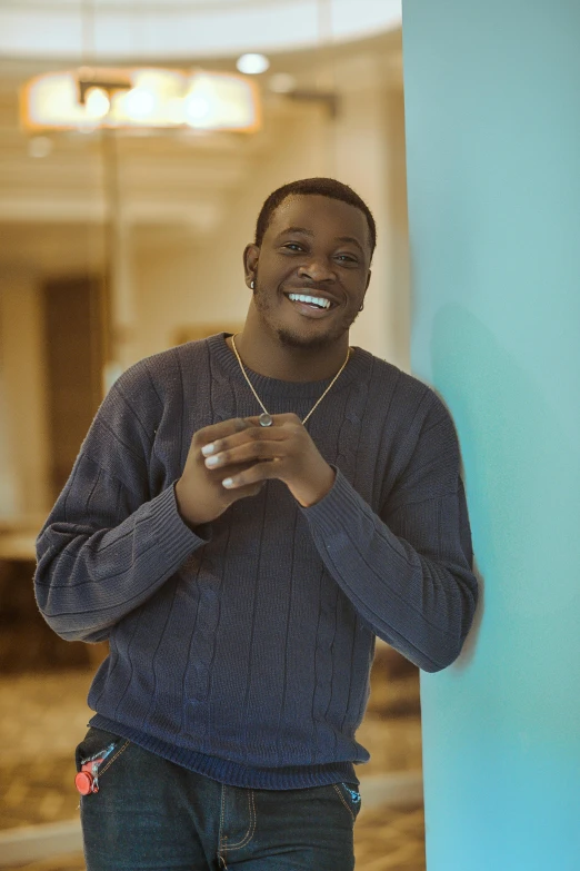 a man wearing a blue sweater and holding a cigarette