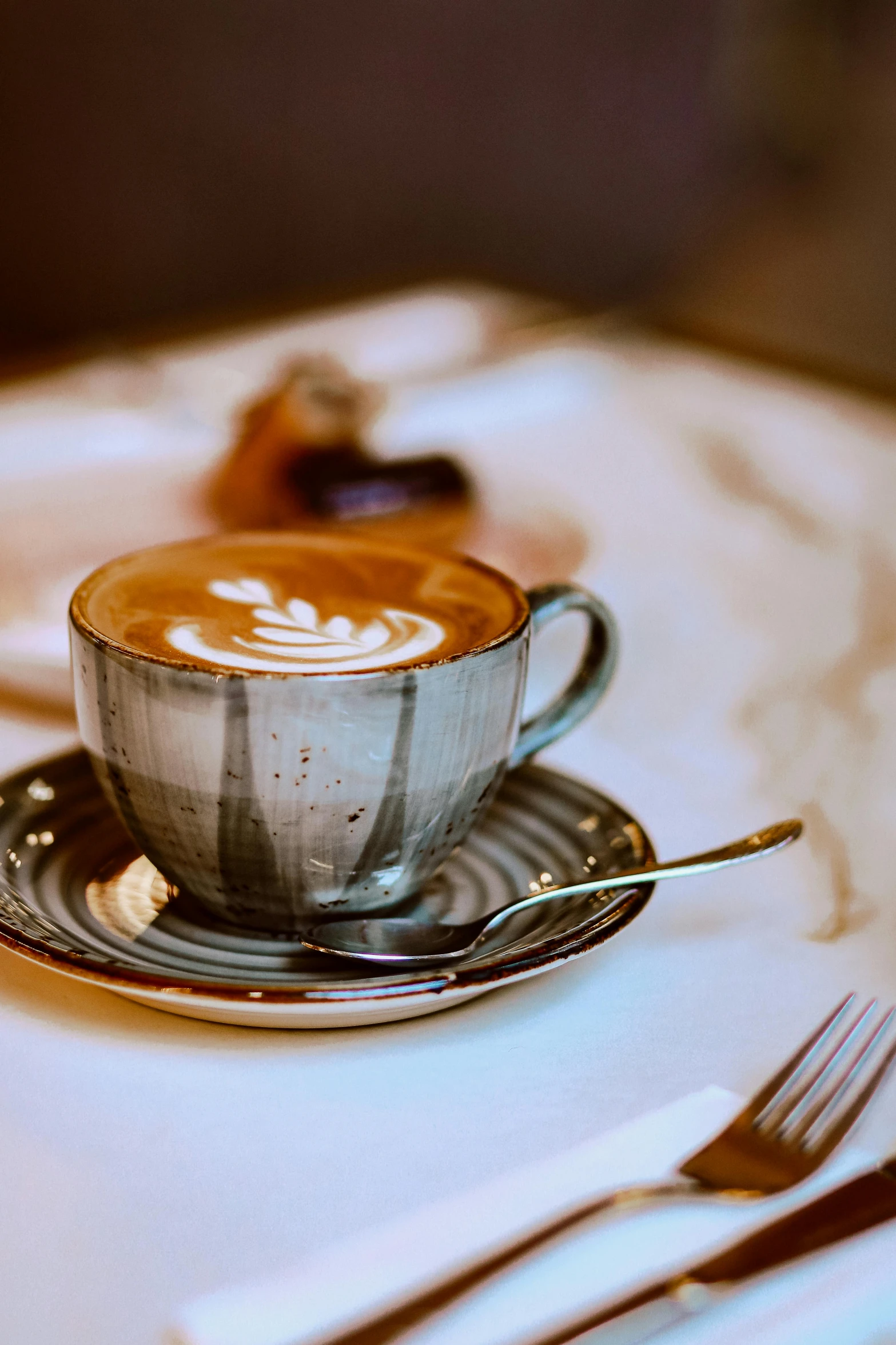 a cup of  chocolate on a saucer, with two forks