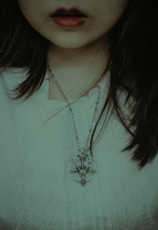 a woman with a white shirt and a long silver necklace