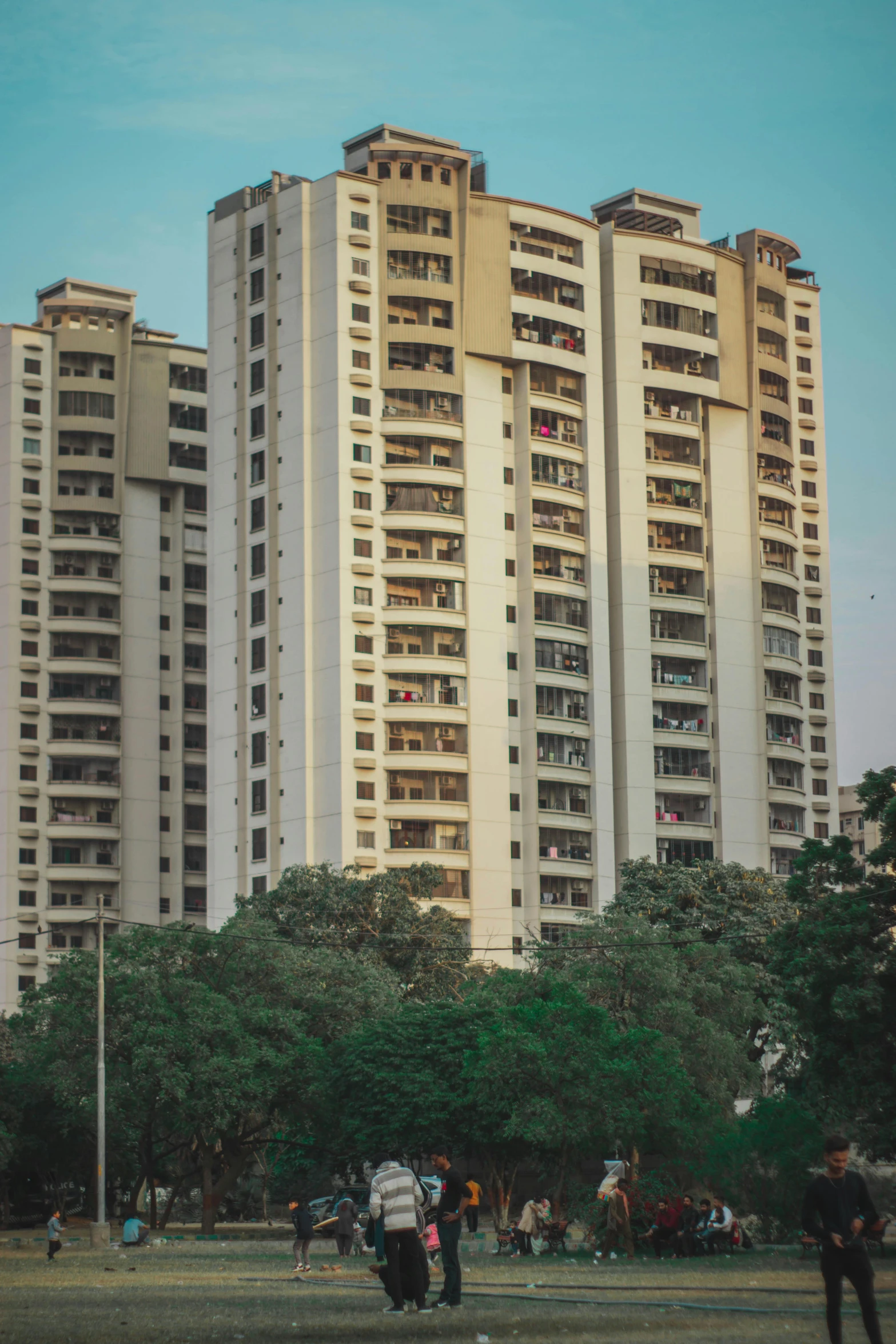 people on the grass next to tall buildings