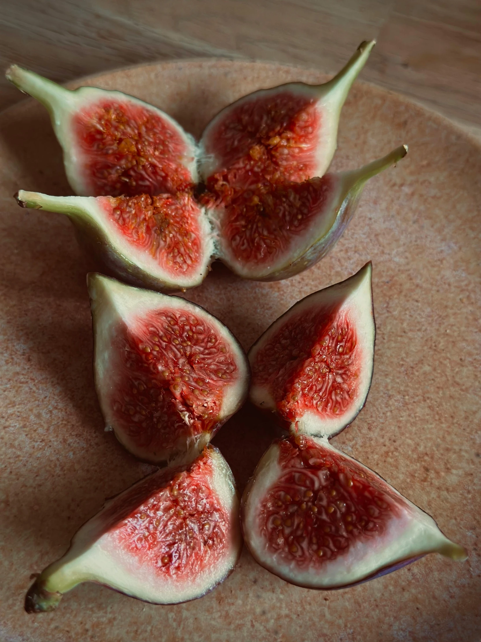 sliced figs on a plate with one sliced in half and the other whole cut open