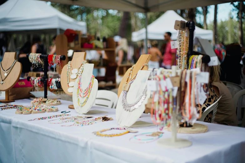 many necklaces are displayed at an outdoor festival