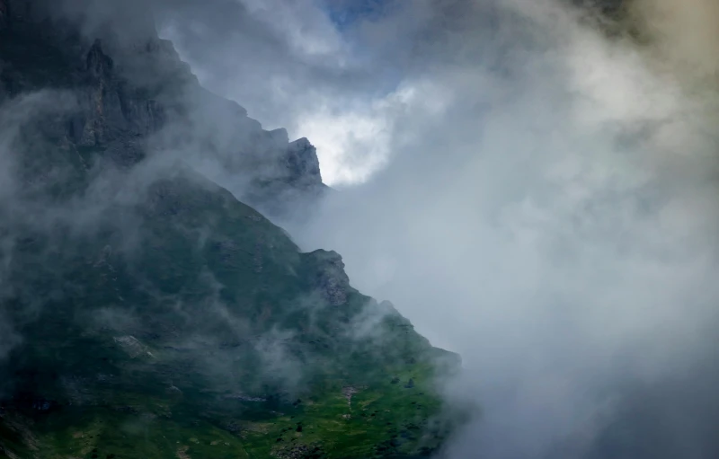 green mountains with clouds moving over them