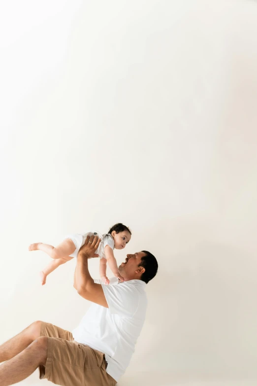 a man lifts his baby up into the air