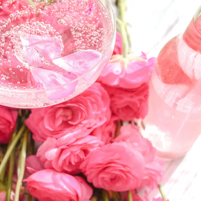 a bouquet of flowers is next to bottles of pink and white water