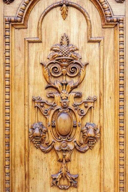 a door with wooden carving that features an ornate pattern and a bird like motif