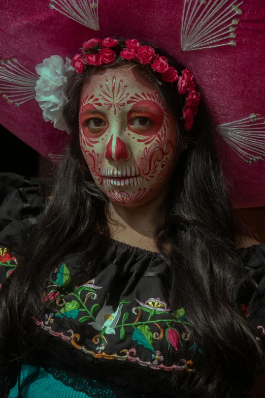 a woman in mexican costume is holding a pink pillow