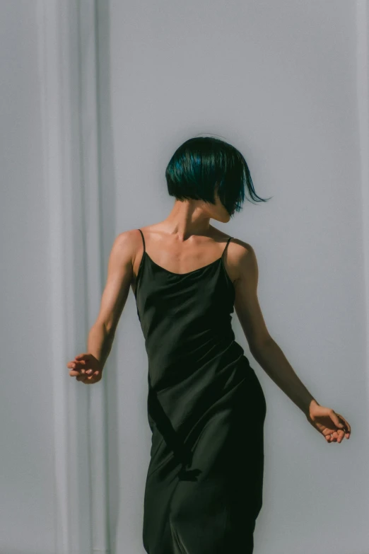 a woman with green hair in a black dress