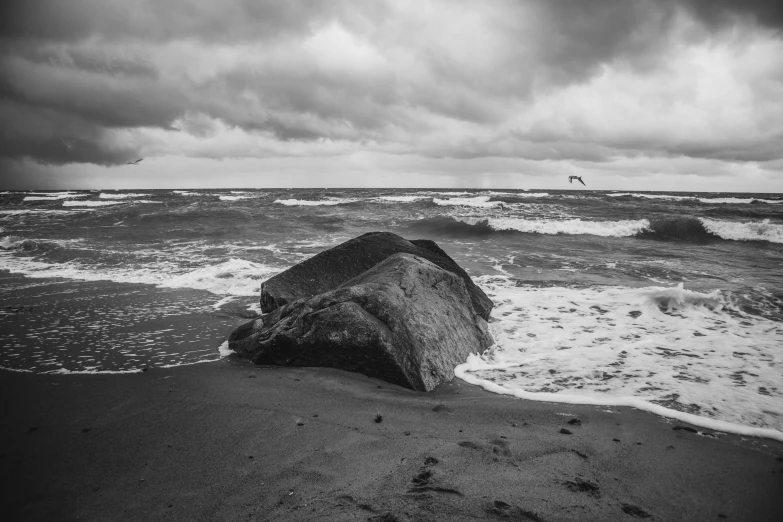 an ocean view with a large rock sticking out of the water