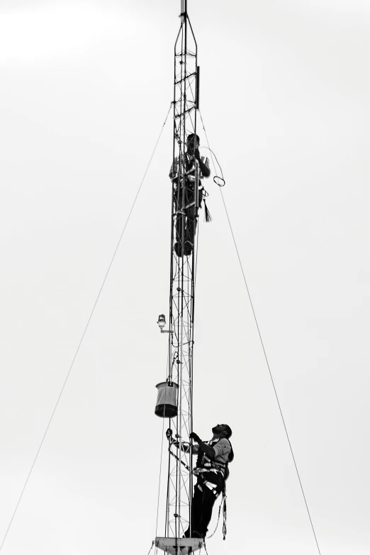 two people climb down on the side of a tower