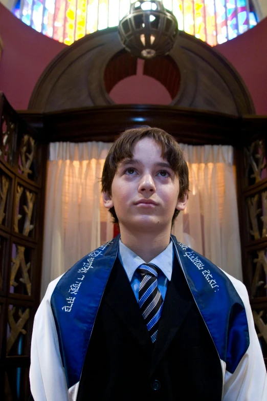 a boy dressed in black vest and tie