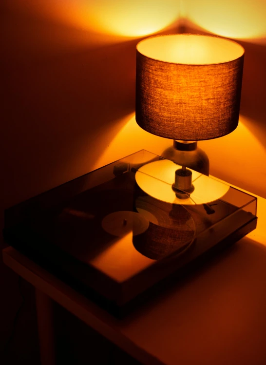 the small table has a lamp and a small record player on it