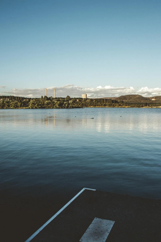 a view over a lake while standing in the distance