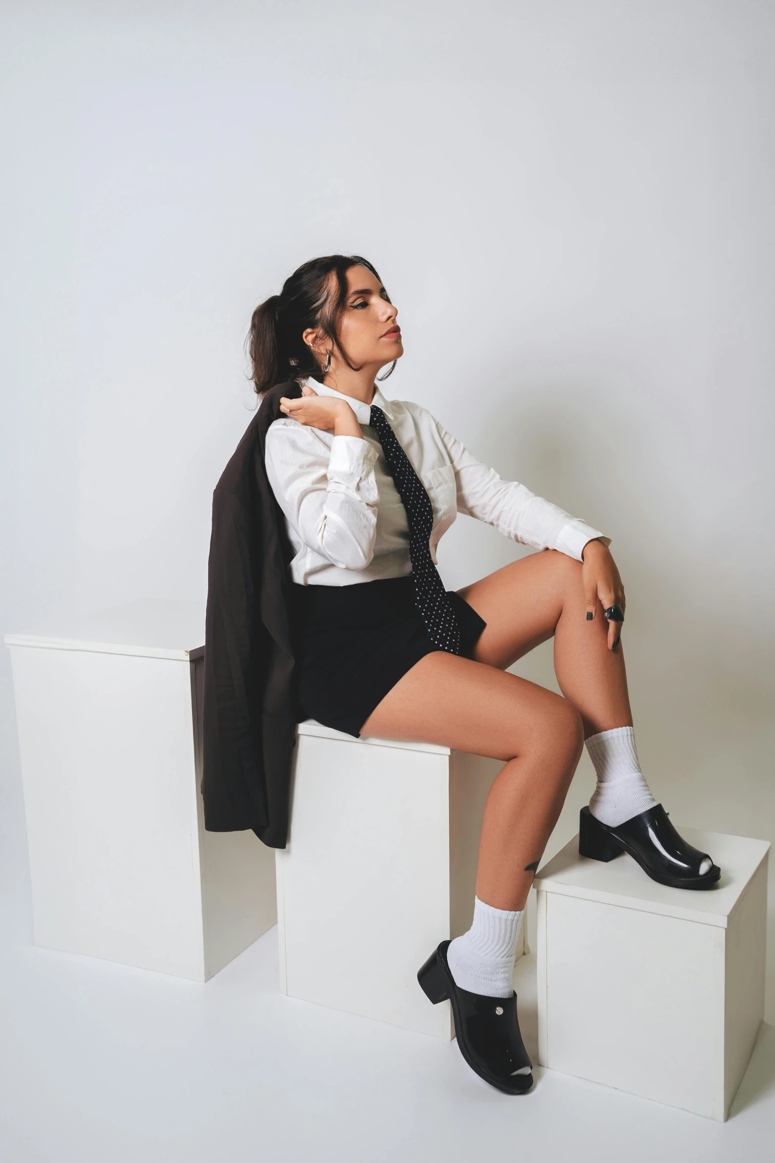 a female with a tie on sitting on some square objects