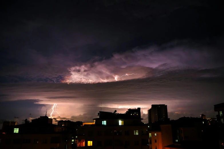 a storm is coming over the city at night