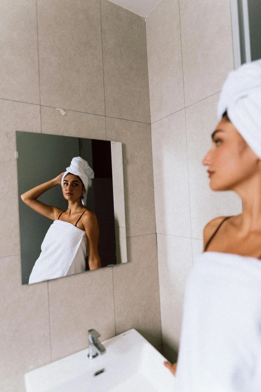 a woman in towel is standing in the bathroom