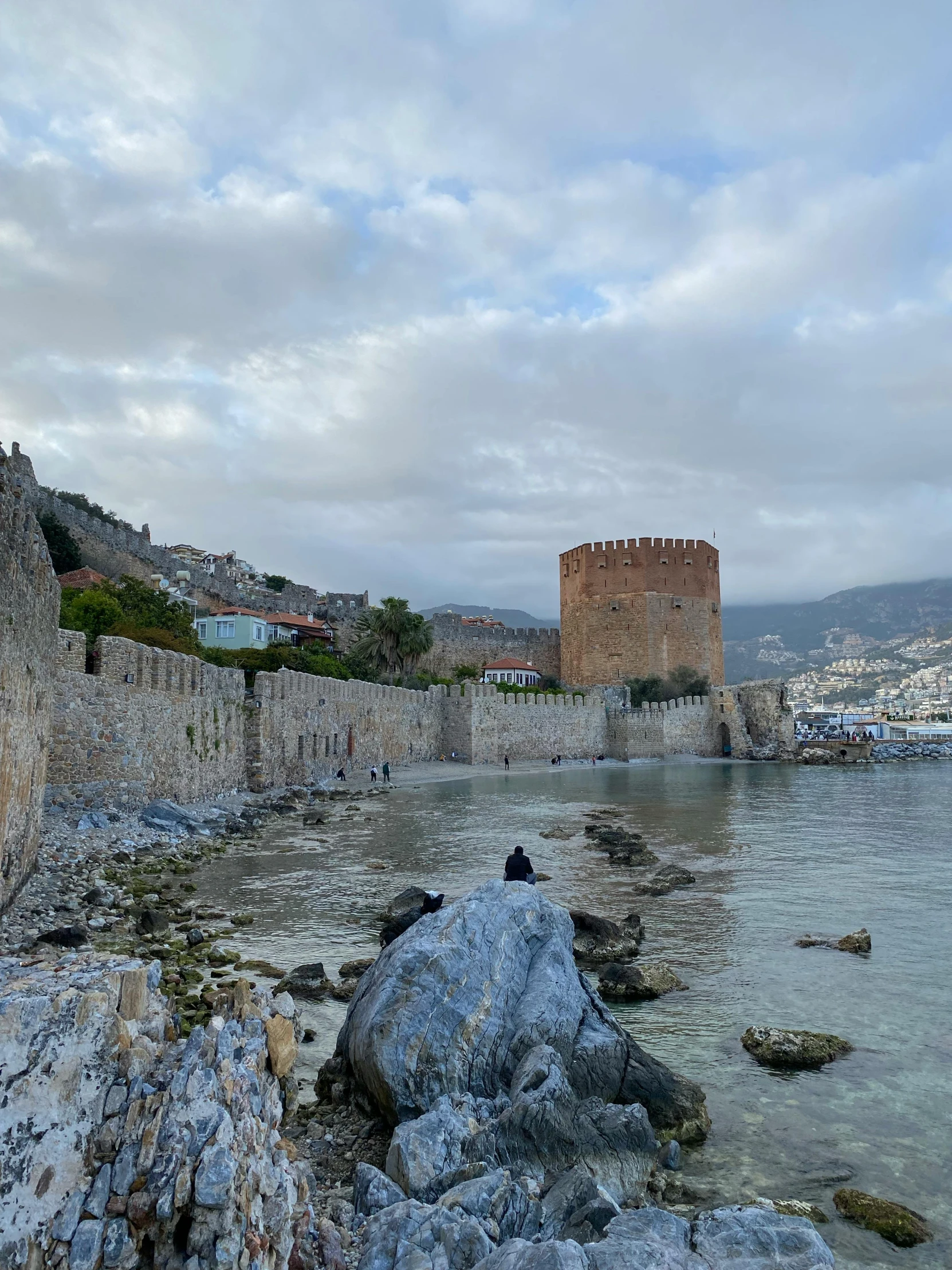 a small tower is next to a beach and a bay