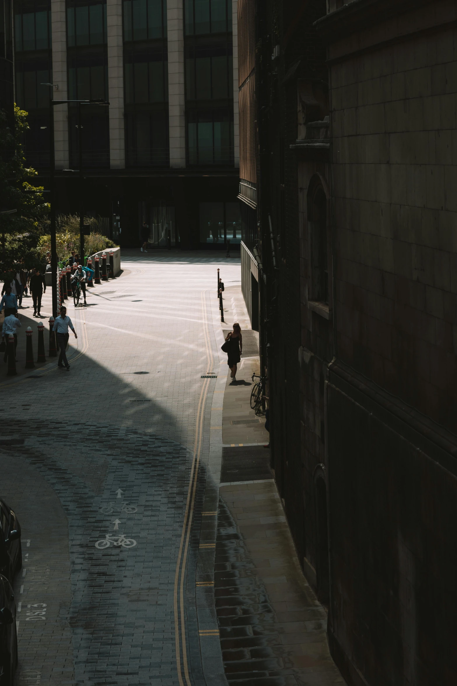 several people are on a city street next to tall buildings