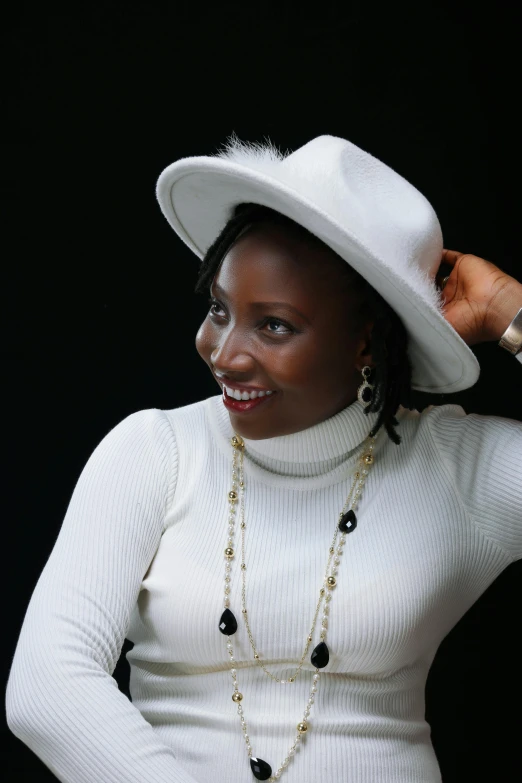 woman in a white outfit and hat posing for camera