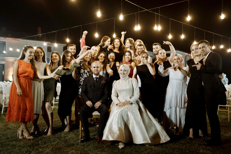 a group of people dressed up at a night time wedding