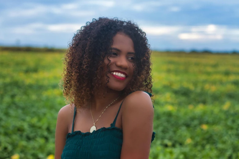 a black woman standing in a field with a sky background