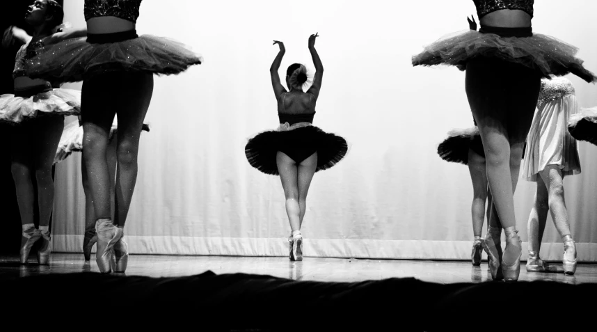 a trio of ballet dancers stand in line