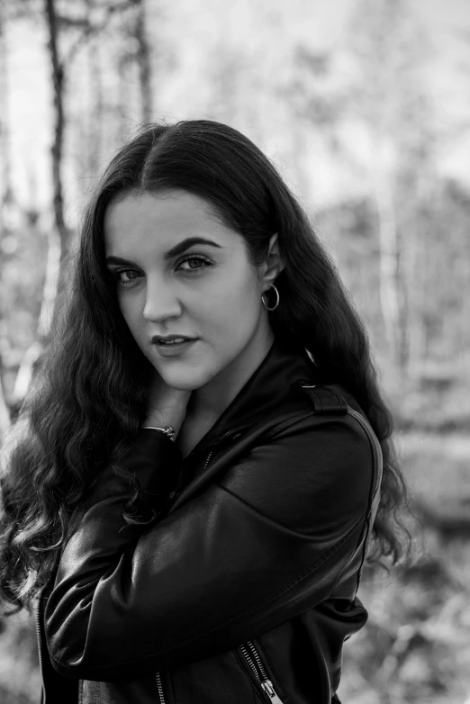 a black and white po of a woman leaning against a tree