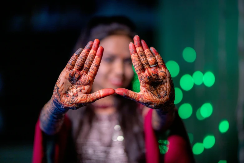 girl with painted hands making a frame with hands