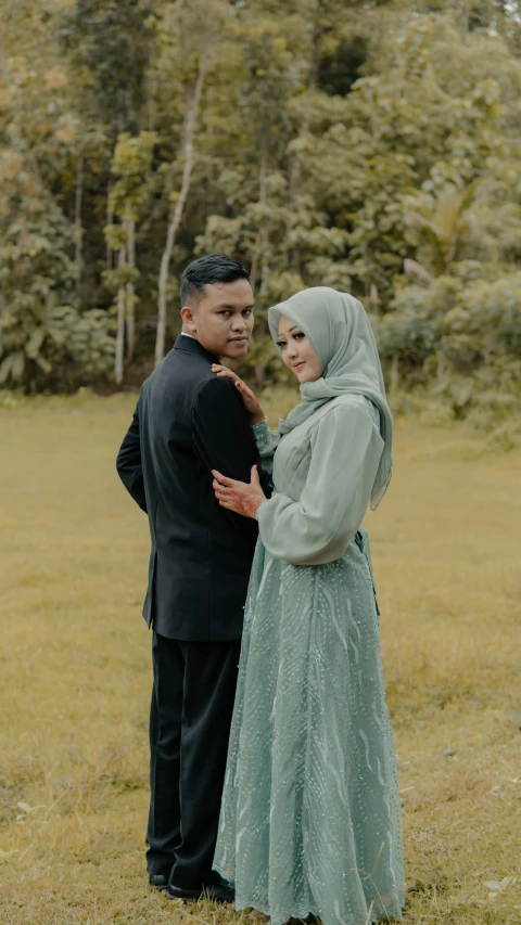 the man and woman are standing in a field