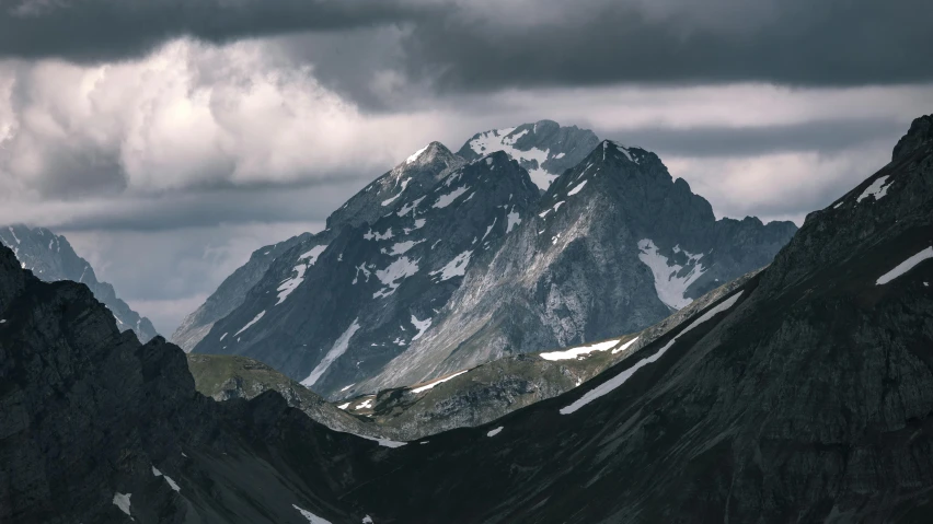 the mountains are majesticly detailed against the dark cloudy sky