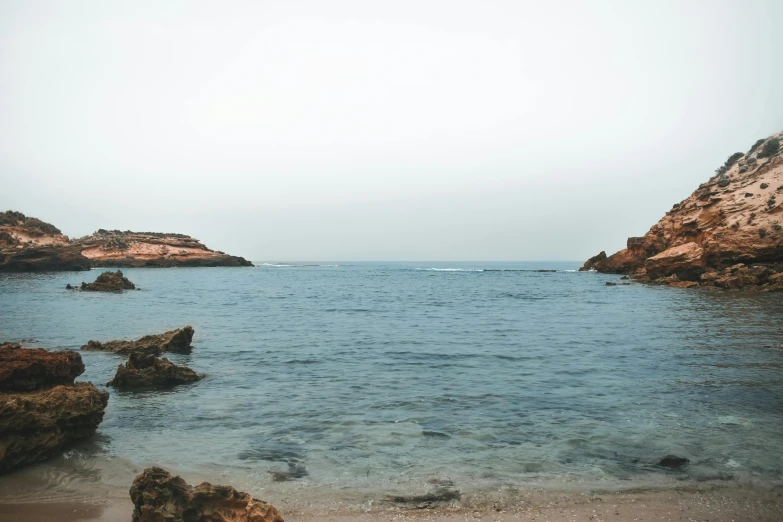 a boat is out in the water near rocks