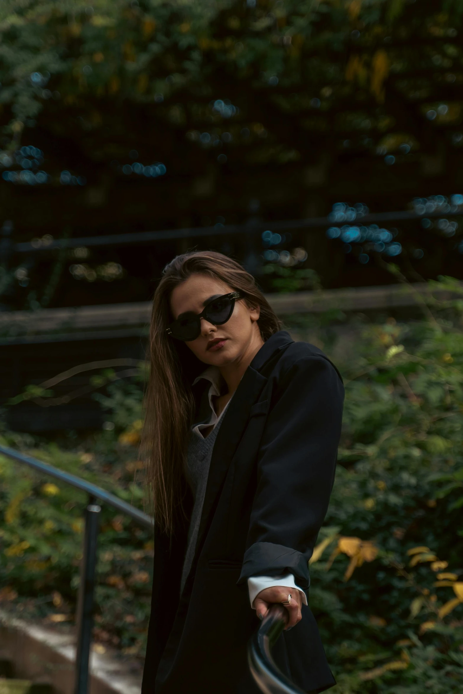 a beautiful young woman with dark hair and sunglasses carrying a suitcase