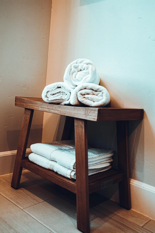 an old wooden table with towels stacked on it
