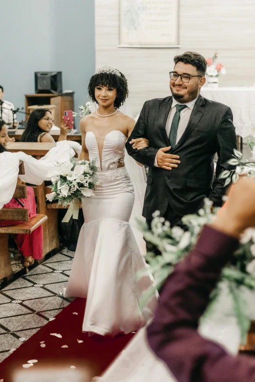 a couple are standing in the aisle after their ceremony