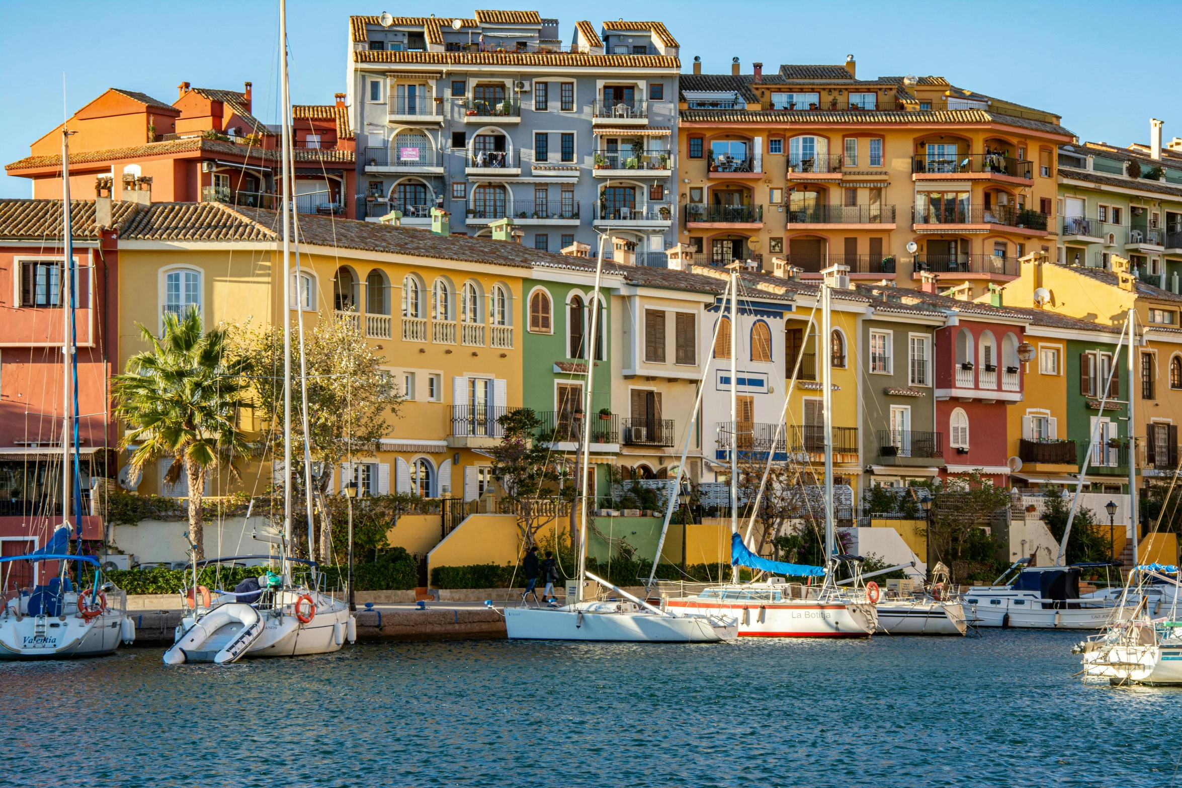 boats are docked in the harbor next to colorful buildings