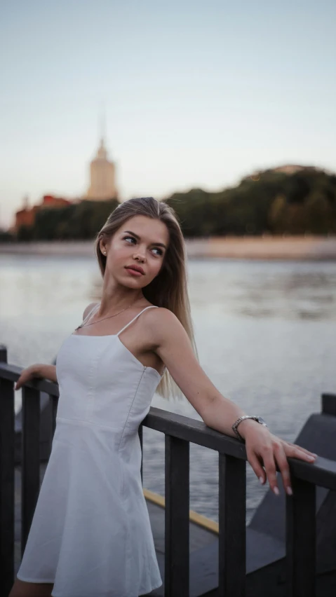 a girl standing next to a railing looking at the camera