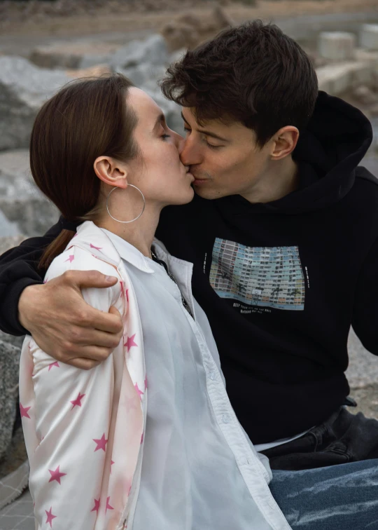 a young man kissing the head of an attractive young woman