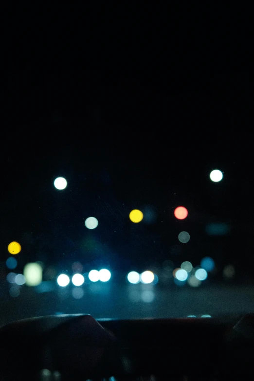 blurry view of the lights in the headlights of a car at night