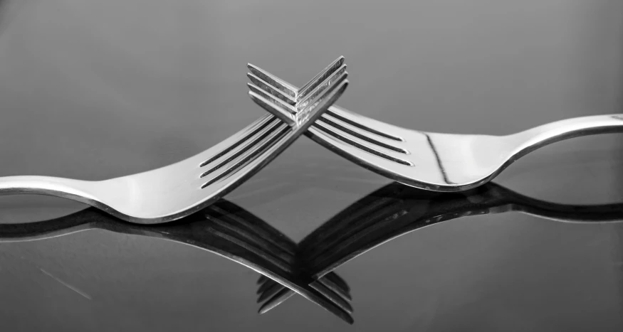 a close up view of forks and knives on a black surface