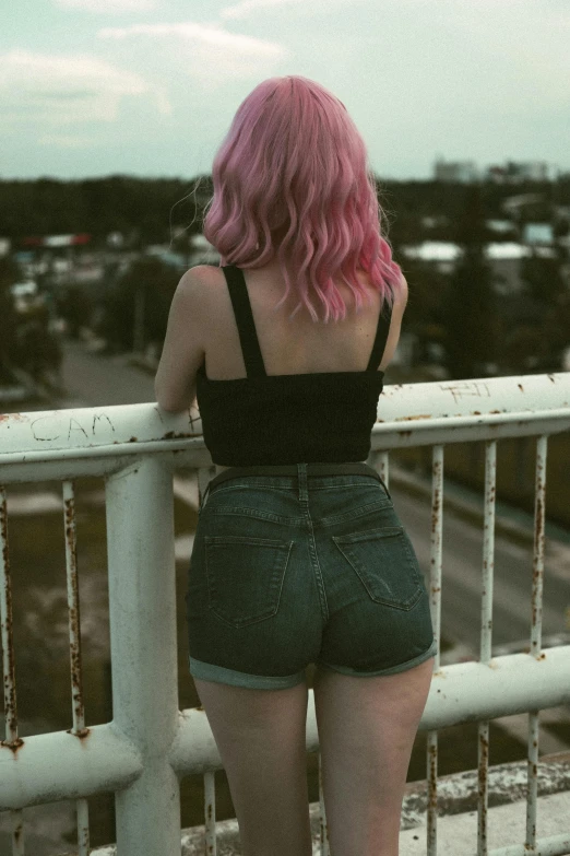 a pink hair girl wearing black shirt looking at the city