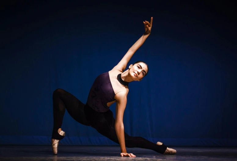 a woman stretching with her arm bent in a dance pose