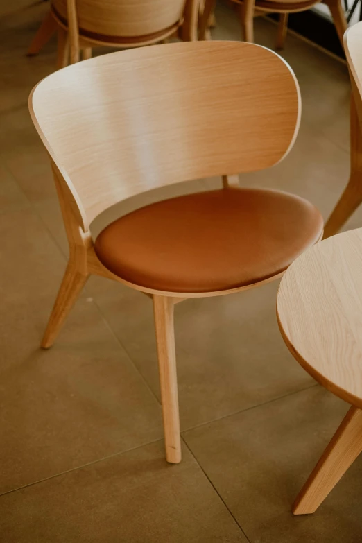 a wooden chair sitting in a living room next to another wooden chair