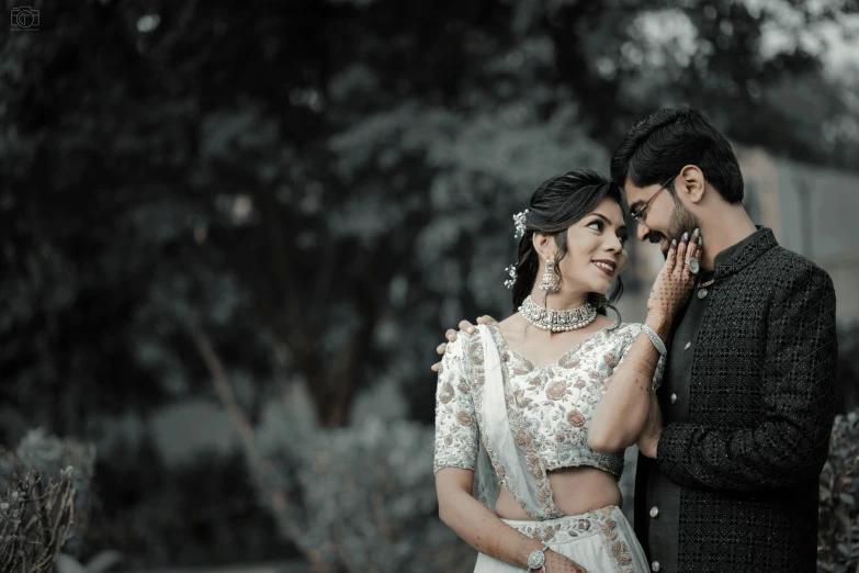 an indian couple pose together in their wedding po