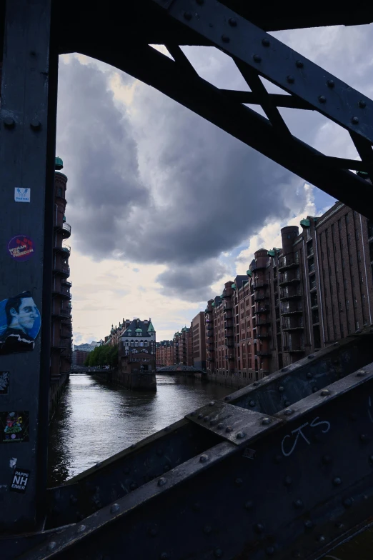 some buildings are next to the river under a bridge