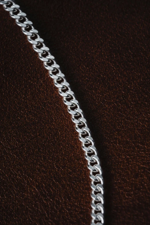 a silver chain on the leather surface