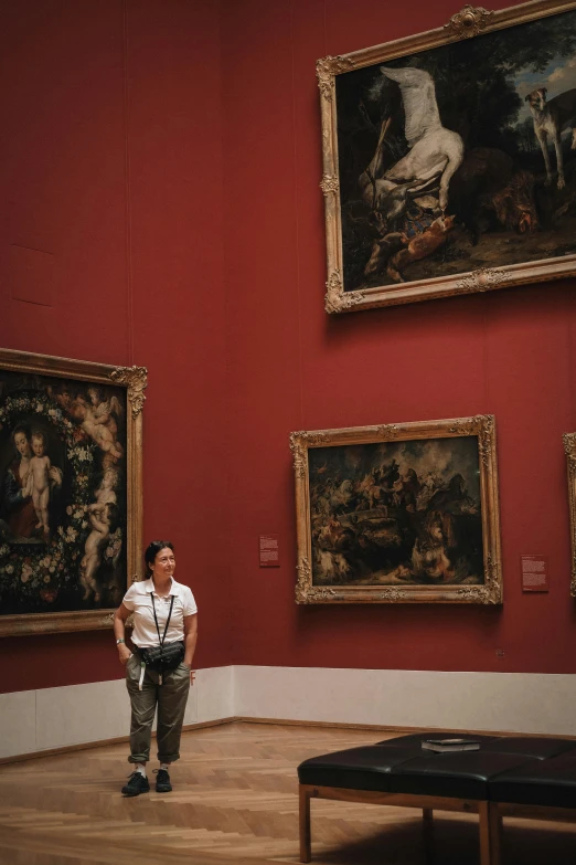 an older man standing in front of some paintings