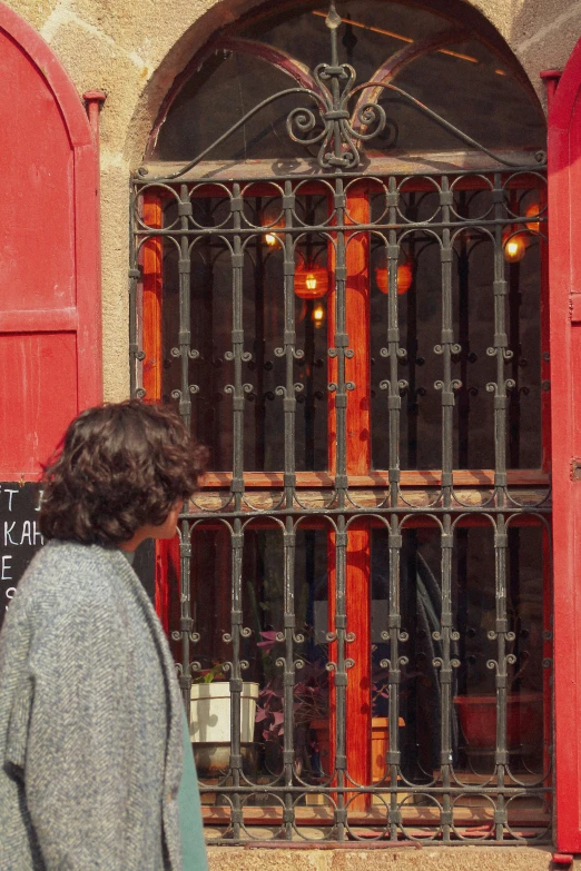 a person stands near a door with a grill on it