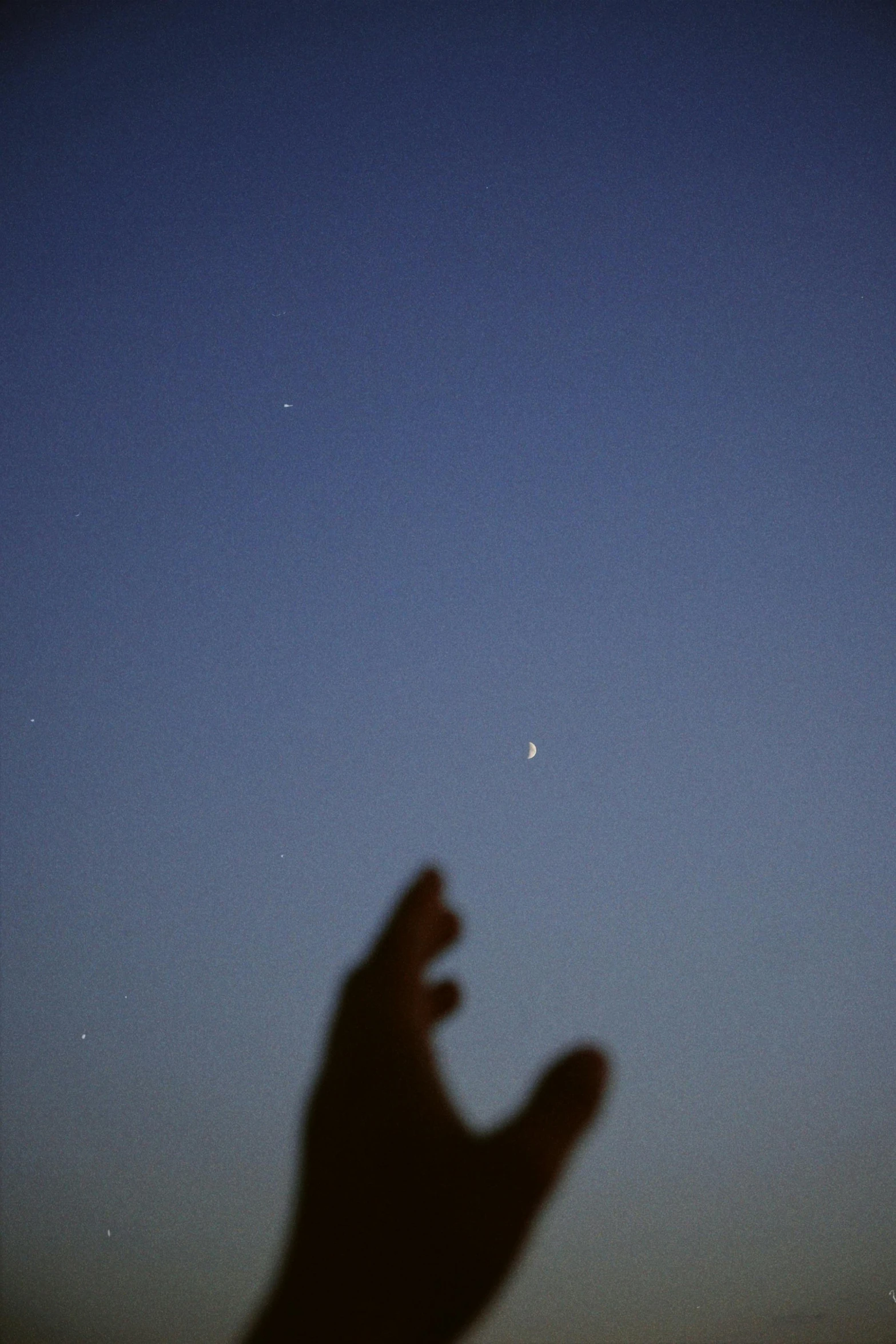 a hand is shown with the moon in the background