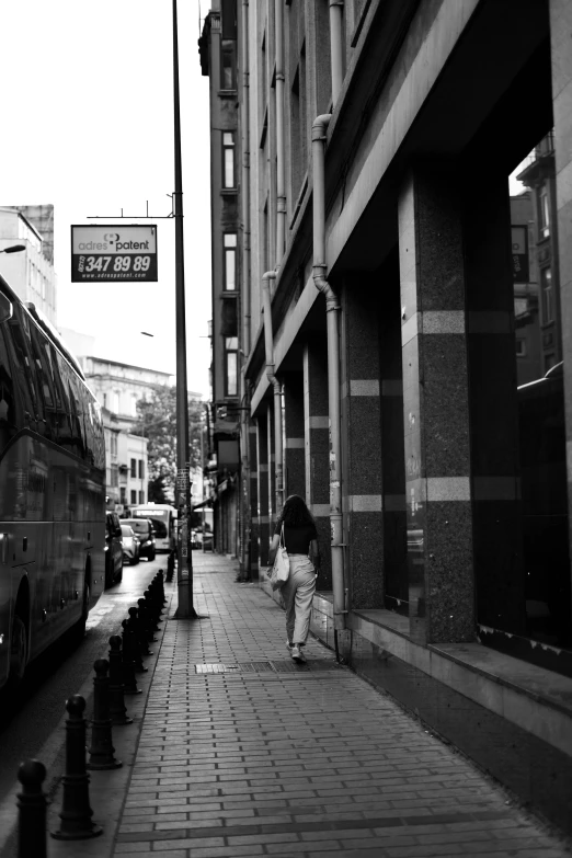 woman walking on city side walk with double decker bus