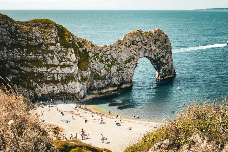 two cliffs standing near the ocean and a beach